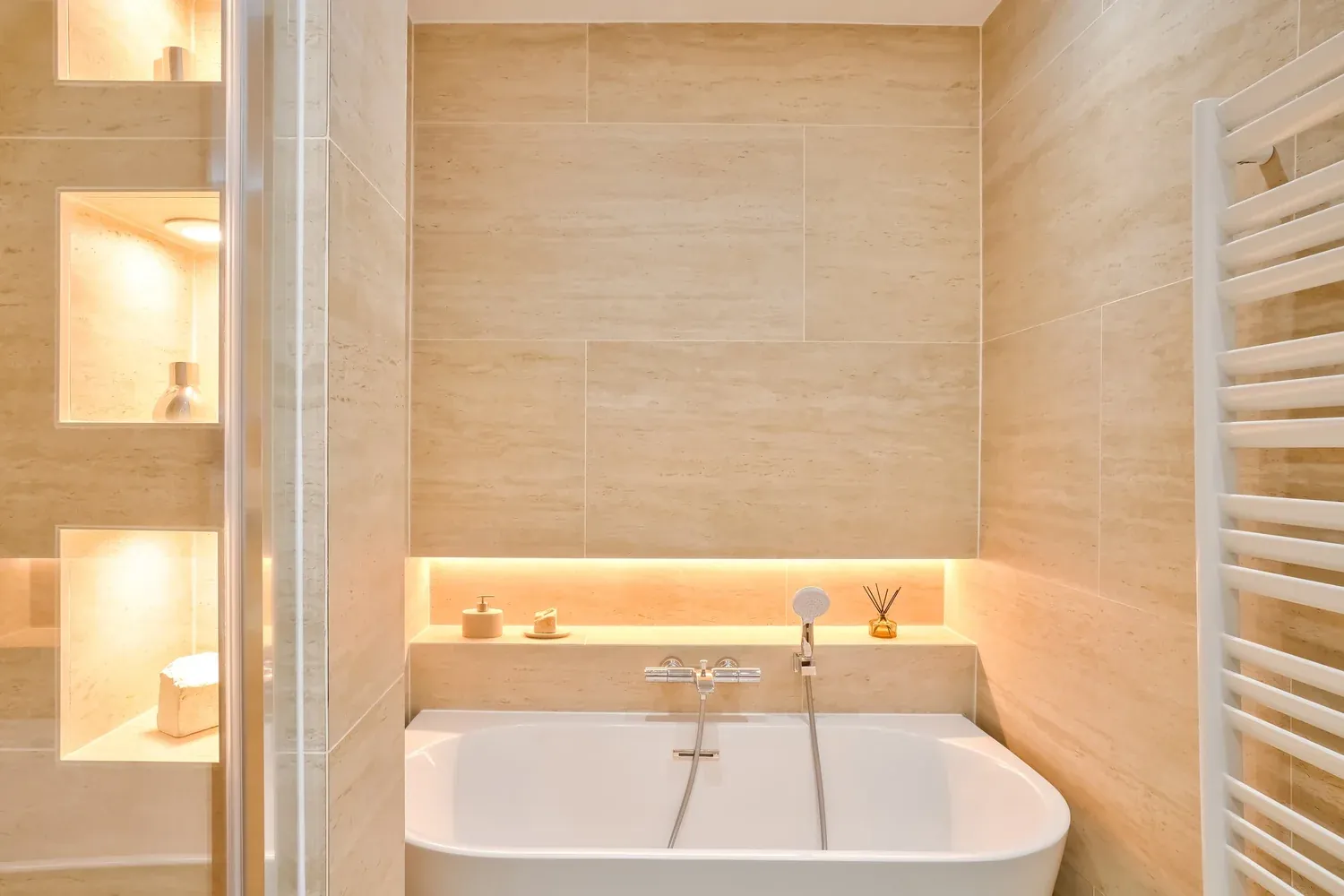 Baignoire îlot et niches éclairées en travertin